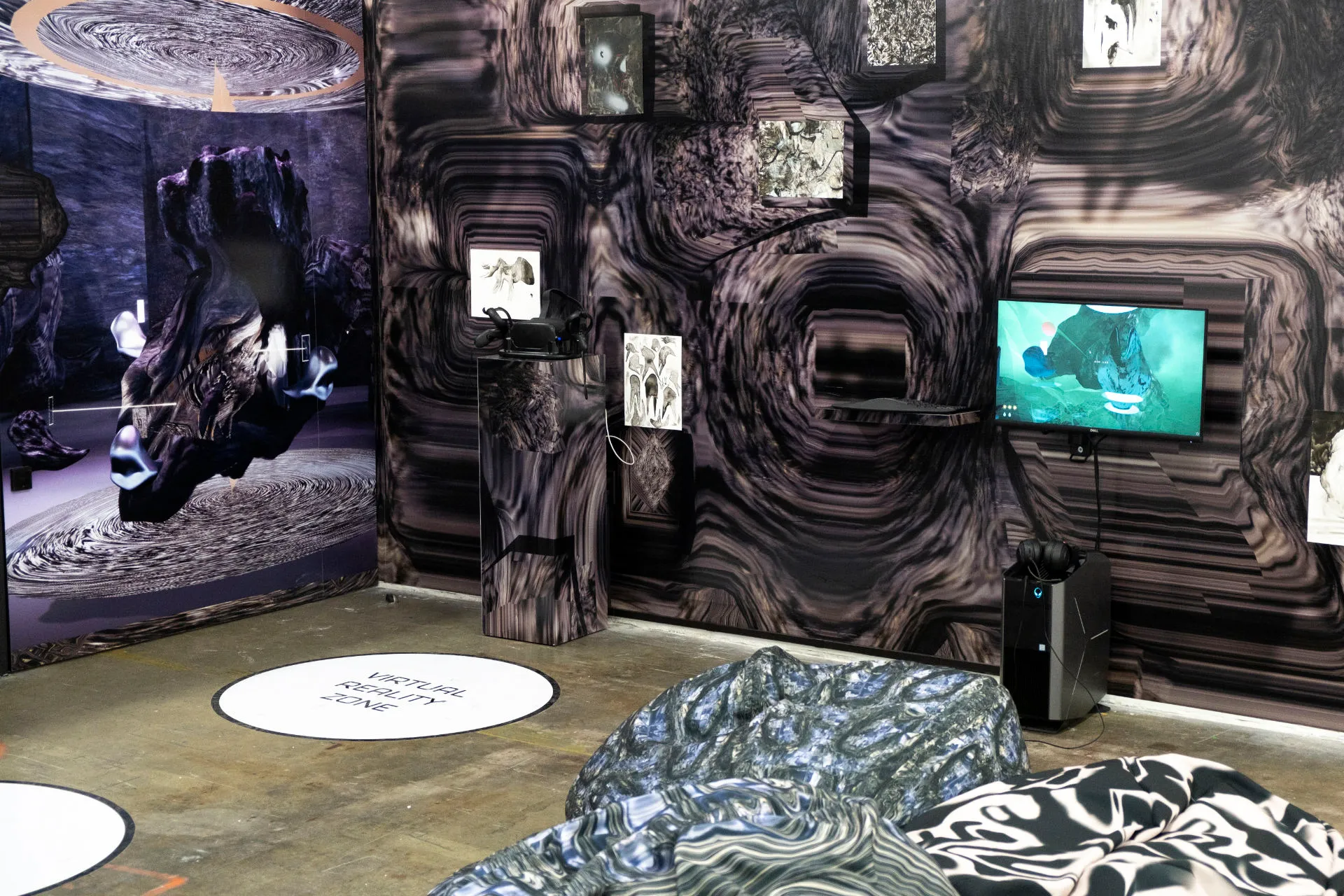 A room with a screen showing the Intensity Testing metaverse scene, with an oculus on a pedestal and wallpaper of the scene on the walls