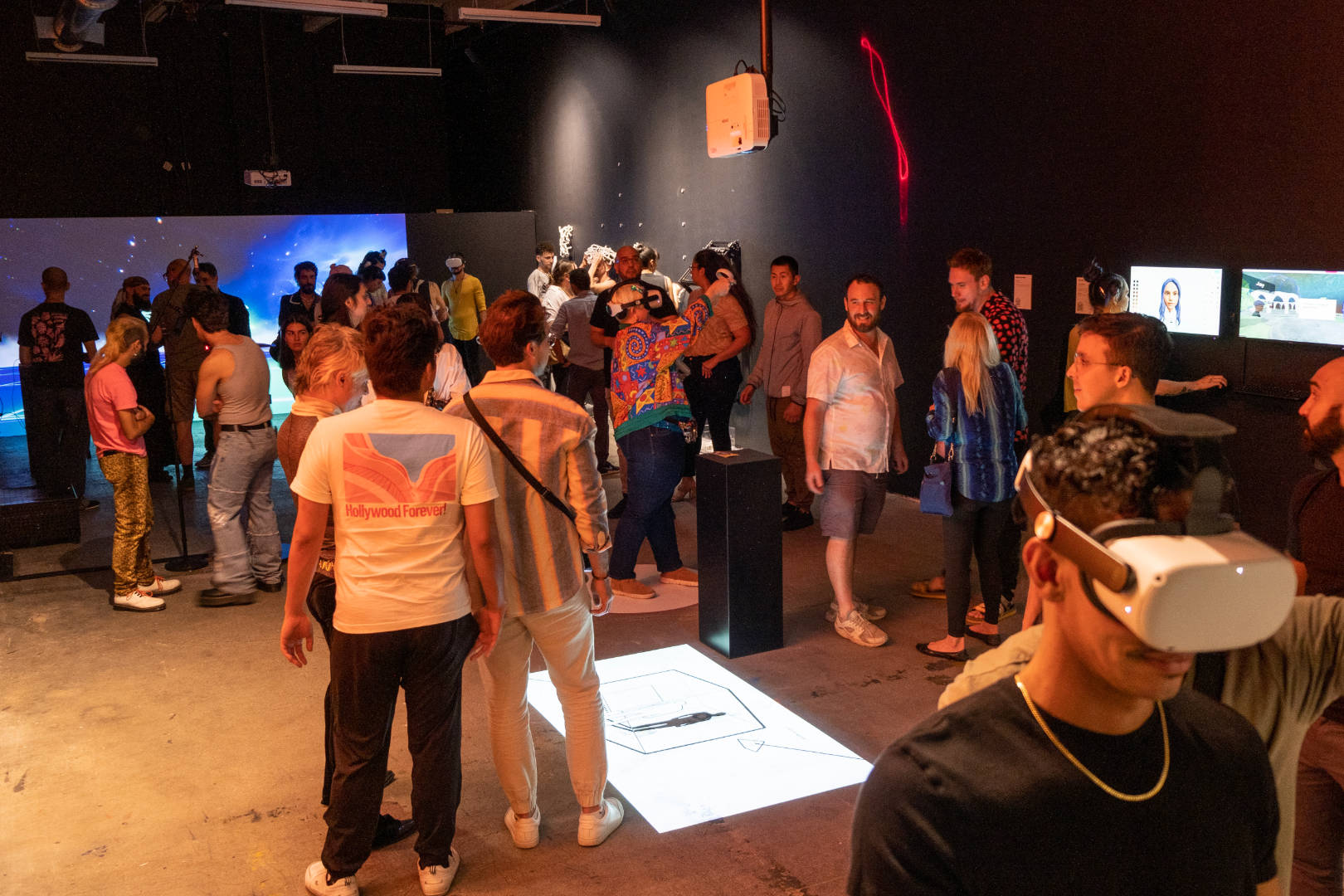 People using Oculus, talking and looking at pieces at the Media Under Dystopia 3.0 exhibition