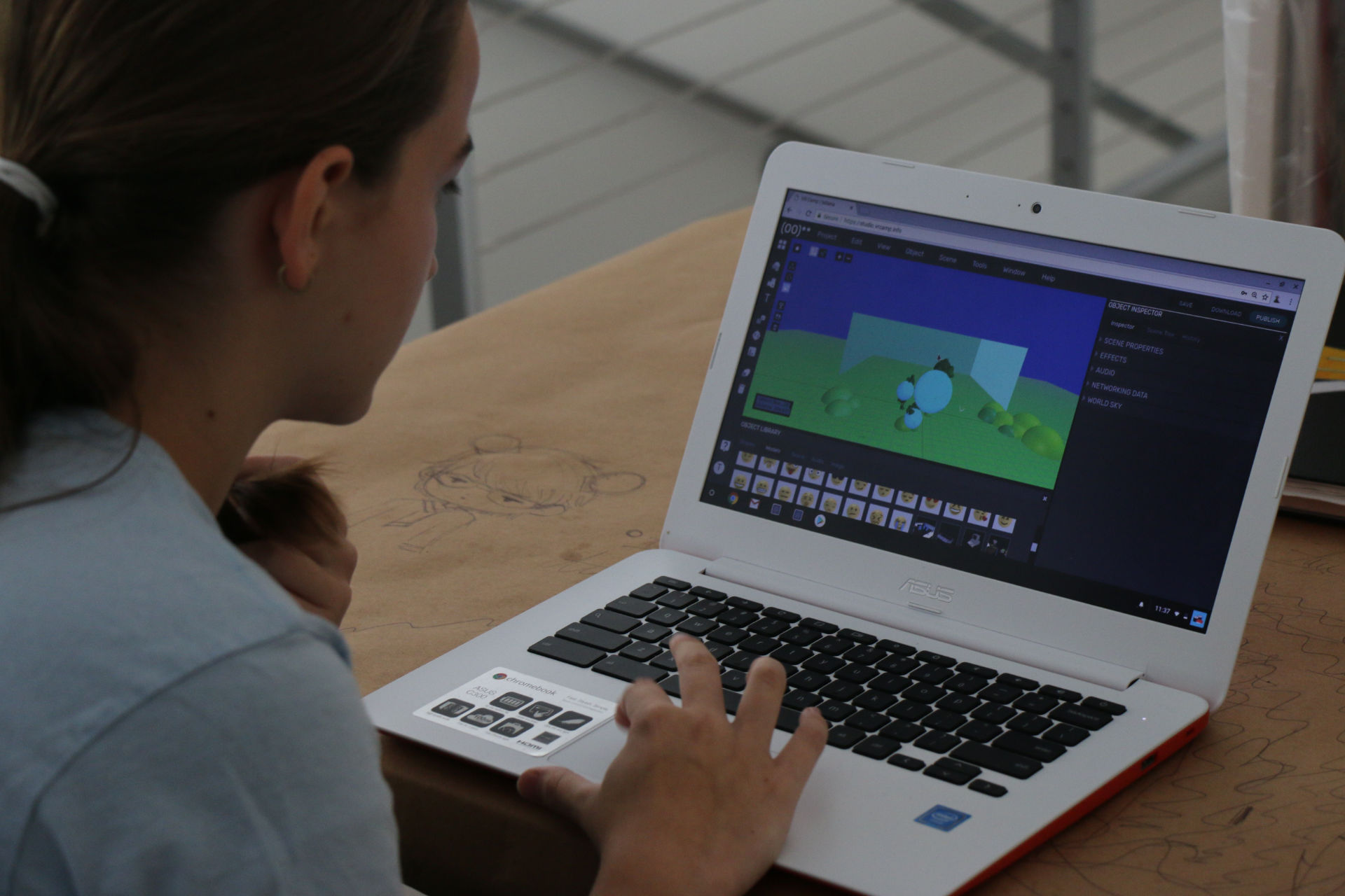 A girl working on her 3D scene on a computer.
