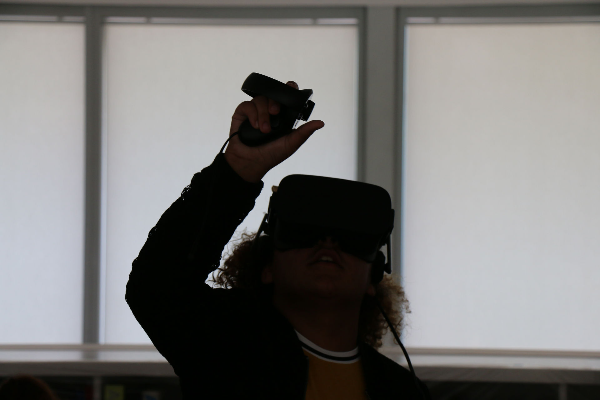 A kid putting her hand up while using an Oculus